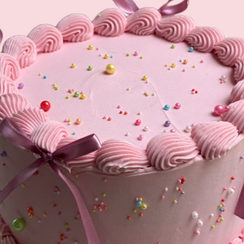 Pastel rosa con moños y chispas de Gallardo Cake